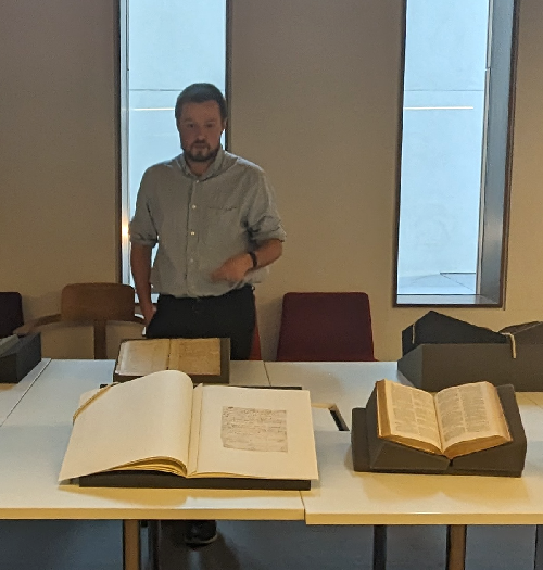 Jack Orchard standing behind a display of various archival items.